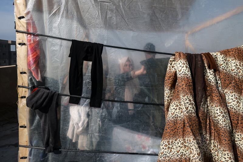 A woman hangs laundry to dry in a camp set up in Rafah by Palestinians who fled Khan Yunis in the southern Gaza Strip. Photograph: Mohammed Abed/AFP via Getty Images
