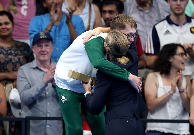 Daniel Wiffen celebrates winning Olympic gold on the podium with Sarah Keane of Swim Ireland. Photograph: James Crombie/Inpho