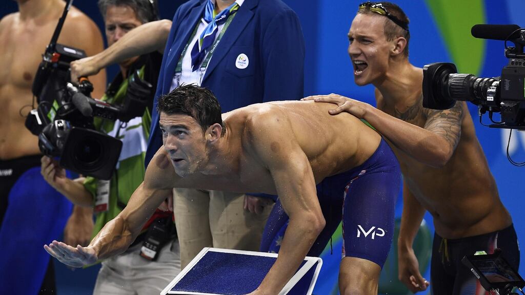 USA’s Michael Phelps and Caeleb Dressel encourage a team-mate during the Men’s 4x100m freestyle relay final. Photograpgh: Gabriel Bouys/AFP/Getty Images