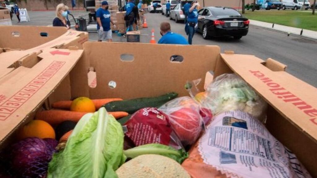 Staff and volunteers with The Los Angeles Dodgers Foundation, distribute food and other goods for people facing economic hardship in Huntington Park, California. Photograph: AFP via Getty