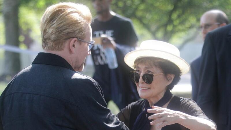 Bono embraces Yoko Ono, widow of Beatles legend John Lennon, at the unveiling of a 24ft x 10ft tapestry depicting the island of Manhattan as a yellow submarine piloted by a waving Lennon at Ellis Island on Wednesday. Photograph: AP