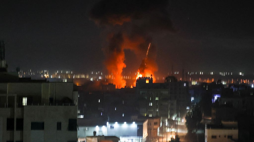 Explosions light up the night sky above buildings in Gaza City early on Wednesday. Photograph: Mahmud Hams/AFP via Getty Images