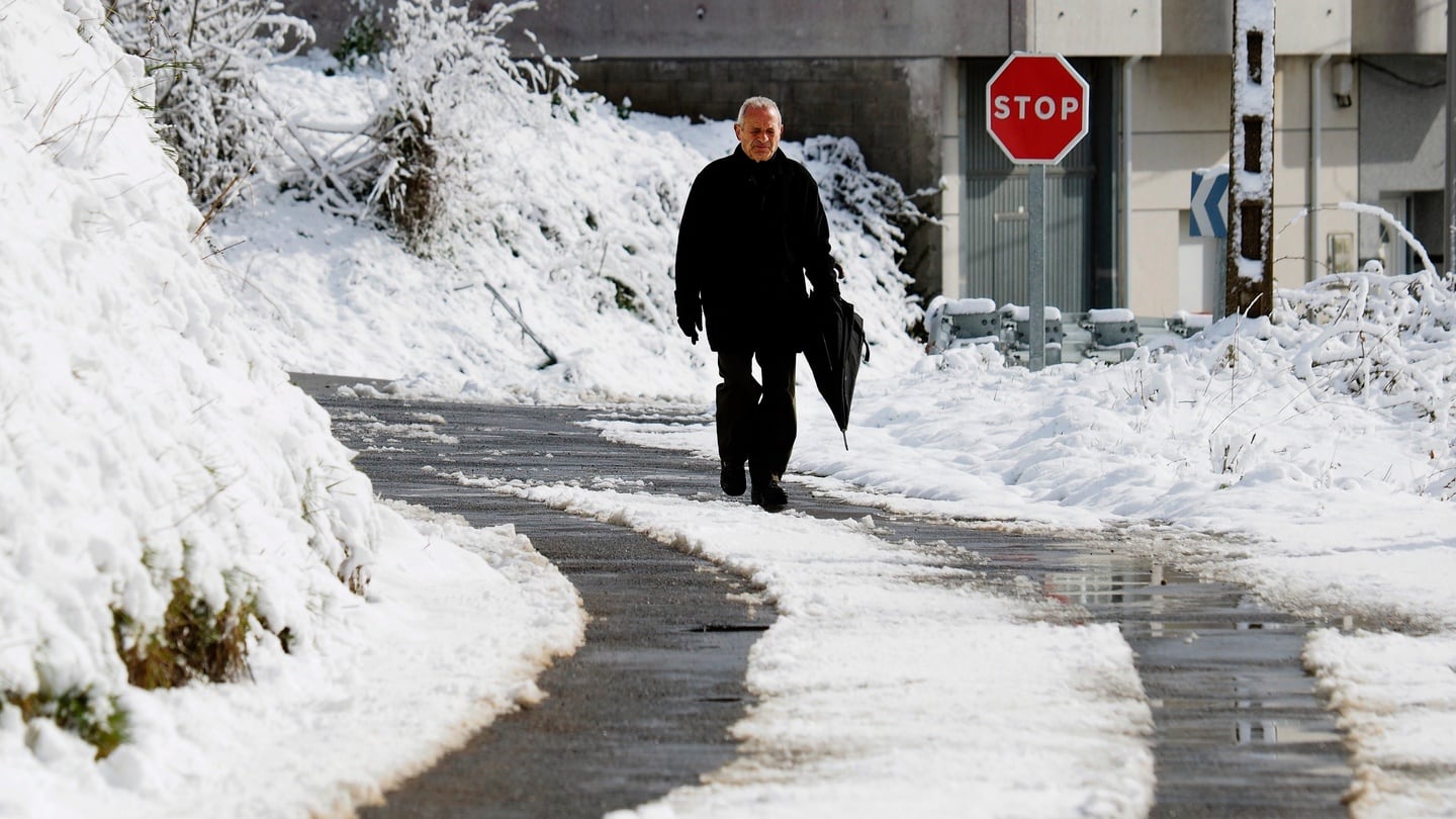 In Spain a man walks on snow-covered road in Piedrafita de o Cebreiro in Galicia. Only last week temperaturs reached more than 22 degrees. Photograph: Eliseo Trigo/EPA