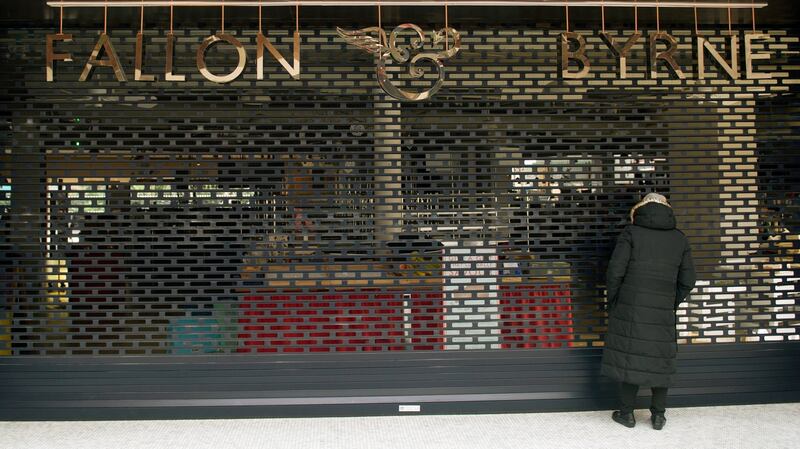 A shopper looks through the shutters of the closed Fallon & Byrne in the Swan Centre, Rathmines. Photograph: Aidan Crawley