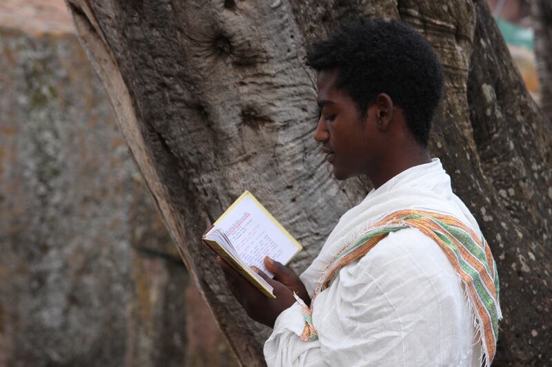 A young man reading a religious book in Lalibela. Photograph: James Jeffrey