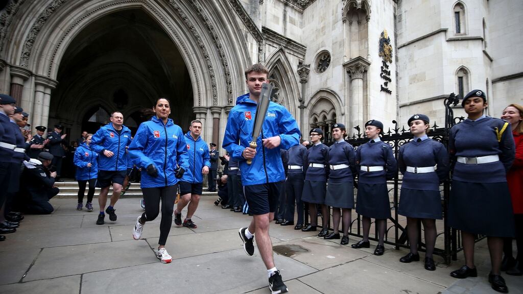 One of the youngest serving members of the RAF, Adam Wood (16) (C) runs with the RAF100 baton outside the Royal Courts of Justice in London, England. Photograph: Steven Paston/PA Wire