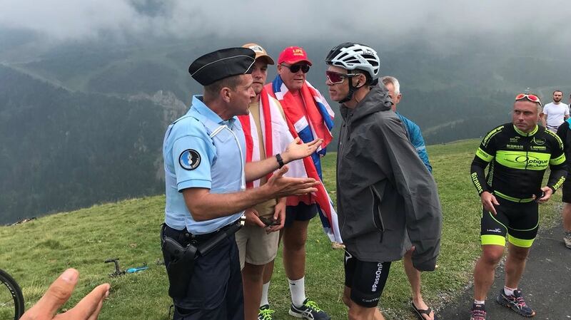 Chris Froome, who was mistaken for a fan, argues with a police officer after he was pulled off his bike on his way to the Team Sky bus. Photo: Albert Secall/Reuters