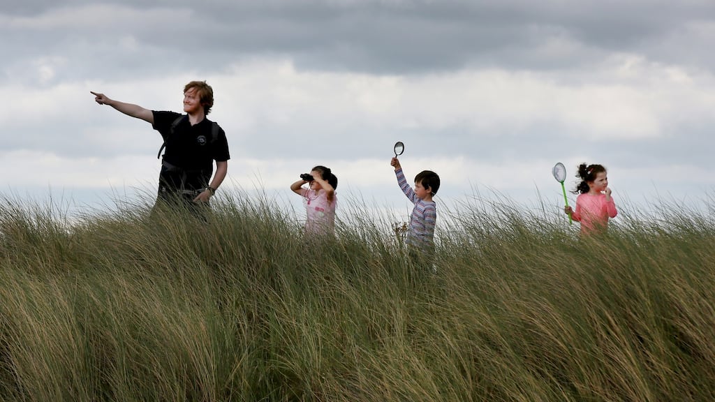 Padraic Creedon of Global Action Plan with, from left, Rosanna Drewilieu (7) from Killester, Dublin, Michael O’Brien (5) from Edenderry, Co Offaly and his sister Hannah (3) on the look-out for the natural heritage of Dublin’s Bull Island for National Heritage Week 2017. Photograph: Mark Stedman