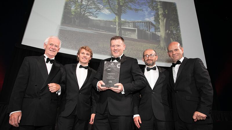 Cathal Healy, Construction Director, Walls Construction, presents the Building of the Year award to the Healy Partners Architects team.