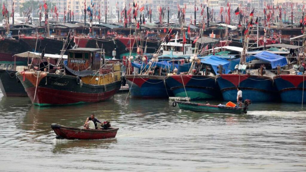 Fishermen drive a boat next to fishing ships docked at a port to shelter from Typhoon Wutip in Sanya, Hainan province. Photograph: Stringer/Reuters