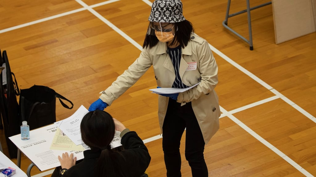 An invigilator wearing a mask and shield to help stop the spread of the coronavirus, distributes exam paper to students in Hong Kong. Irish authorities are exploring what public health measures will be needed to protect students and staff. Photograph: Jerome Favre/AP