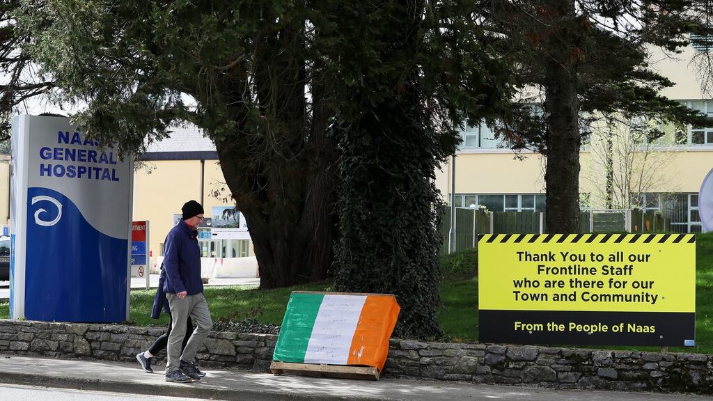 People pass messages of thanks left outside Naas General Hospital as restrictions remain in place to help curb the spread of the coronavirus. Photograph: Brian Lawless/PA Wire