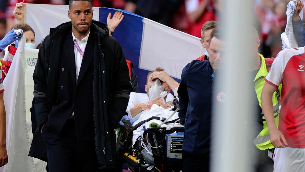Christian Eriksen looks out from a stretcher as he is taken off the pitch after collapsing during Denmark’s opening Euro 2020 game against Finland at the Parken Stadium in Copenhagen. Photograph: Friedemann Vogel/Pool via AP