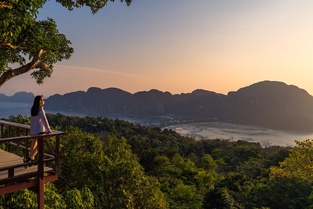 Is having it all and our more, more, more culture still relevant in a world that needs a strong approach to sustainability? A woman standing at Phi Phi view point on Phi Phi Island, Krabi Province, Thailand