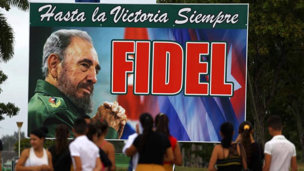 People stand in front of a billboard to Cuba’s late president Fidel Castro in Santa Clara, Cuba. Photograph: Ivan Alvarado/Reuters