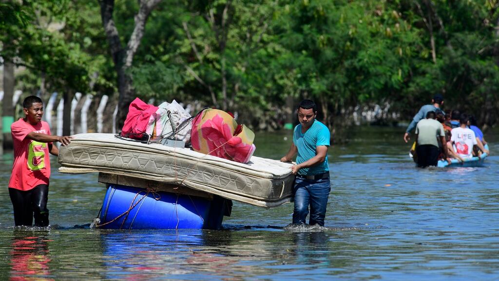 Residents transport their belongings during flooding on Sunday in Coban, Guatemala. Photograph: Getty Images