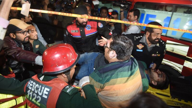 Pakistani policemen and volunteers move an injured victim of a bomb attack in Lahore. Photograph: Arif Ali/AFP/Getty Images
