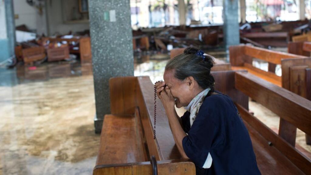 A women sobs while praying in a flooded church in Tacloban, Philippines, on Thursday, six days after the city was largely destroyed by typhoon Haiyan. Photograph: Tyler Hicks/New York Times.
