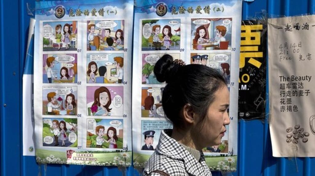 A woman walks by China’s anti-espionage ‘Dangerous Love’ poster campaign. Photograph: Ng Han Guan/AP