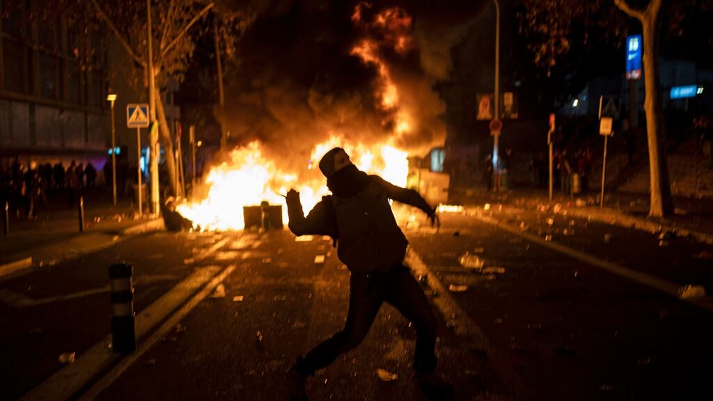 A man throws an object toward the end of a Catalan pro-independence protest outside the Camp Nou stadium in Barcelona. Photo: Felipe Dana/AP Photo