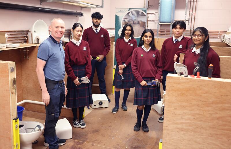 12/05/2025 - NEWS - ADAMSTOWN CC
Paul Hollywood is a teacher at Adamstown Community College, with some TY students, from left; Lianne Esguerra, Musfique Hasan, Kaylesha Naicker, Christina Shaju, Kenneth Low and Nivedha Chandrasekaran,He formerly worked as a plumber before teacher training. He set up an innovative apprenticeship module in the school that gives students hands-on experience of trade skills, where they get to install and plumb toilets and radiator systems. 
Photograph: Dara Mac Dónaill / The Irish Times