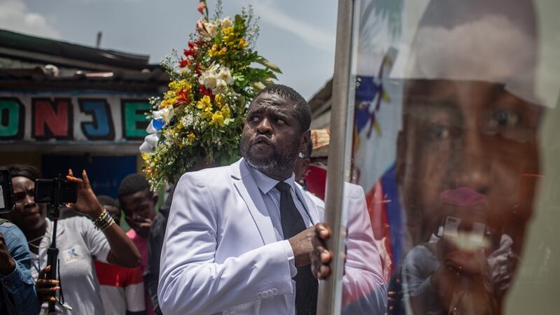 Jimmy Cherizier, who runs the G9 gang, holds a portrait of assassinated President Jovenel Moïse. Photograph: Victor Moriyama/The New York Times