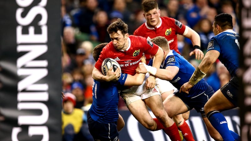 Darren Sweetnam in the red of Munster is tackled by two Leinster players at the Aviva Stadium earlier this season. Photograph: James Crombie/Inpho