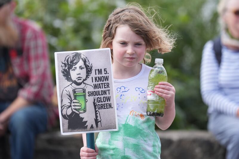 Five-year-old Ailbhe Urquhart with a bottle of Lough Neagh water at the lough statue in Antrim. Photograph: Niall Carson/PA