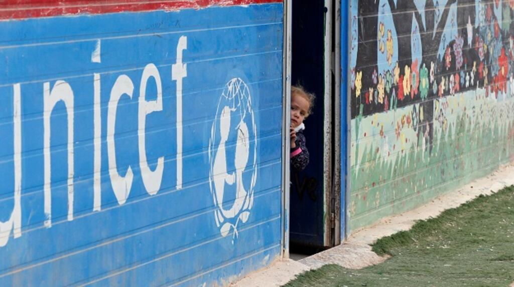 A Syrian child peeks out from a Save the Children center during the visit of Nobel Peace Prize winners Tawakkol Karman of Yemen and Shirin Ebadi of Iran to Al Zaatari refugee camp in Jordan, near the border with Syria. Photograph: Muhammad Hamed/Reuters