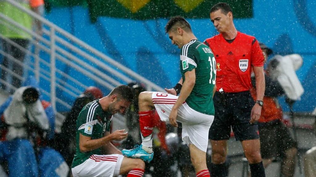 Mexico’s Miguel Layun pretends to tie the shoelaces of team-mate Oribe Peralta after he scored his side’s goal in the Group A game against Cameroon at Dunas Arena in Natal. Photograph: Toru Hanai/Reuters