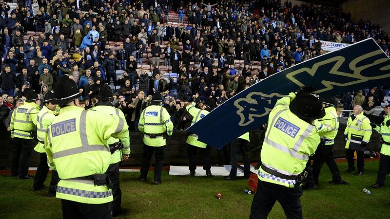 An advertising board is thrown at police as they attempt to prevent a pitch invasion after the FA Cup match between Wigan Athletic and Manchester City at DW Stadium. Photograph: Gareth Copley/Getty Images