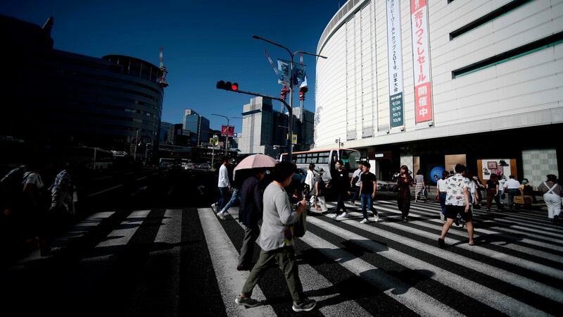 People cross a street in Kobe City centre. Photograph: Filippo Monteforte/AFP/Getty