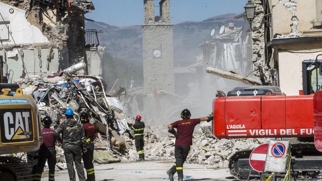 Members of the Italian fire brigades operate near civic tower, in the earthquake-stricken town of Amatrice, on Monday. Photograph: Massimo Percossi/EPA