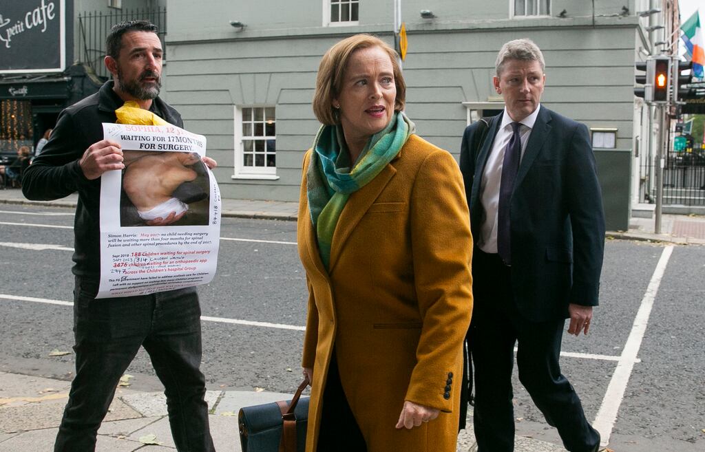 Chief Executive of Children’s Health Ireland Eilish Hardiman passes demonstrator Aaron Daly from Dún Laoghaire (who is holding a photo of his daughter when she was on the scoliosis waiting list in 2018) on her way to an Oireachtas health committee on issues relating to spinal surgery at Temple St Children's Hospital. Photograph: Gareth Chaney/Collins Photos