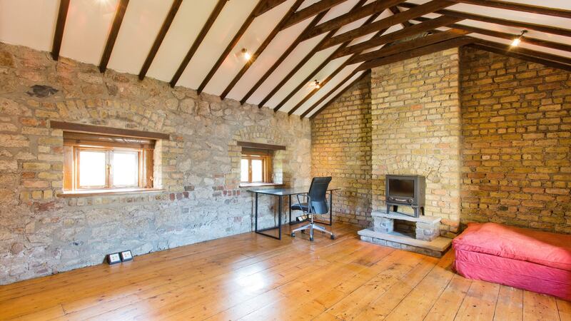 The bedroom stretches the entire width of the house, a stove lies at the gable end of the room