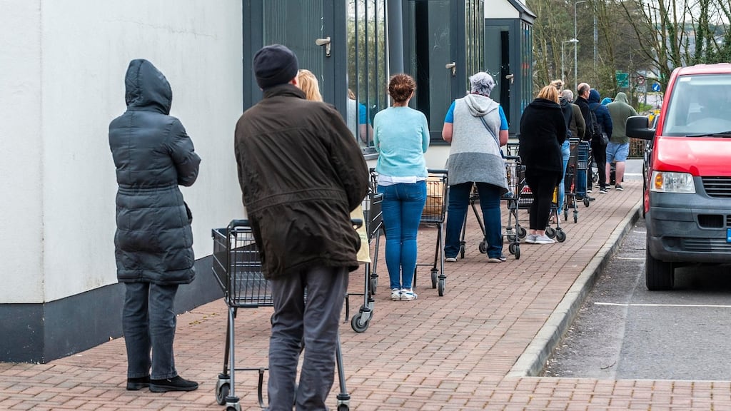 Shoppers observe social distancing while queuing outside Dunne Stores in Clonakilty, Co Cork. Photograph: Andy Gibson