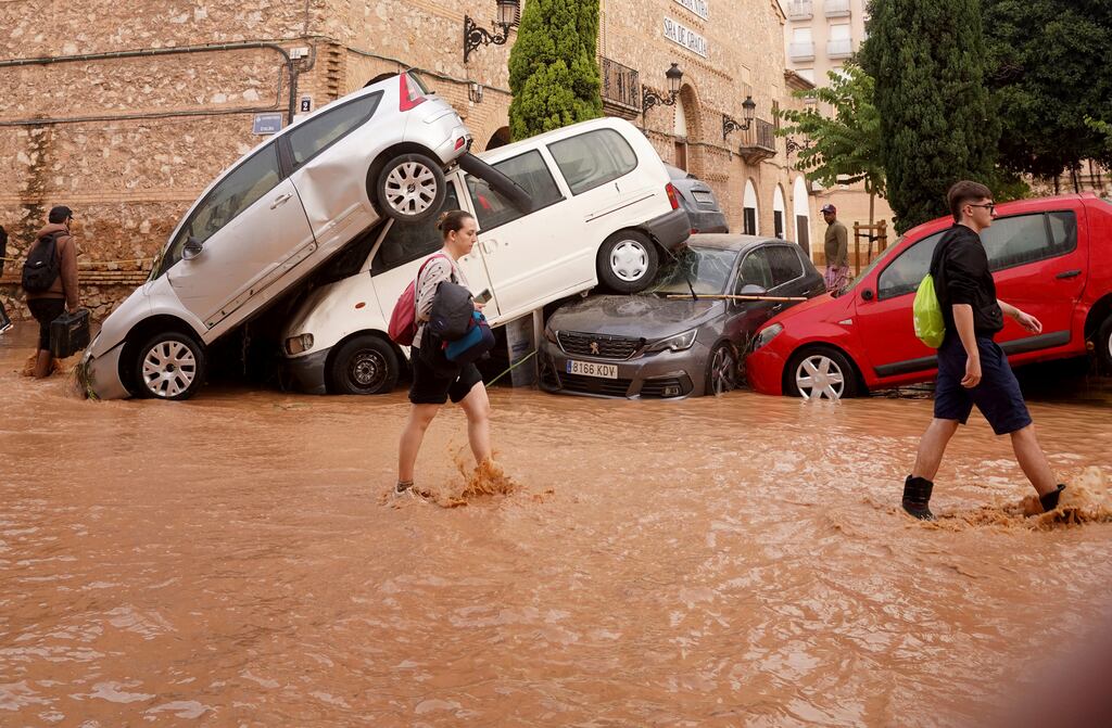 Residents walk through flooded streets in Valencia. Photograph: Alberto Saiz/AP
