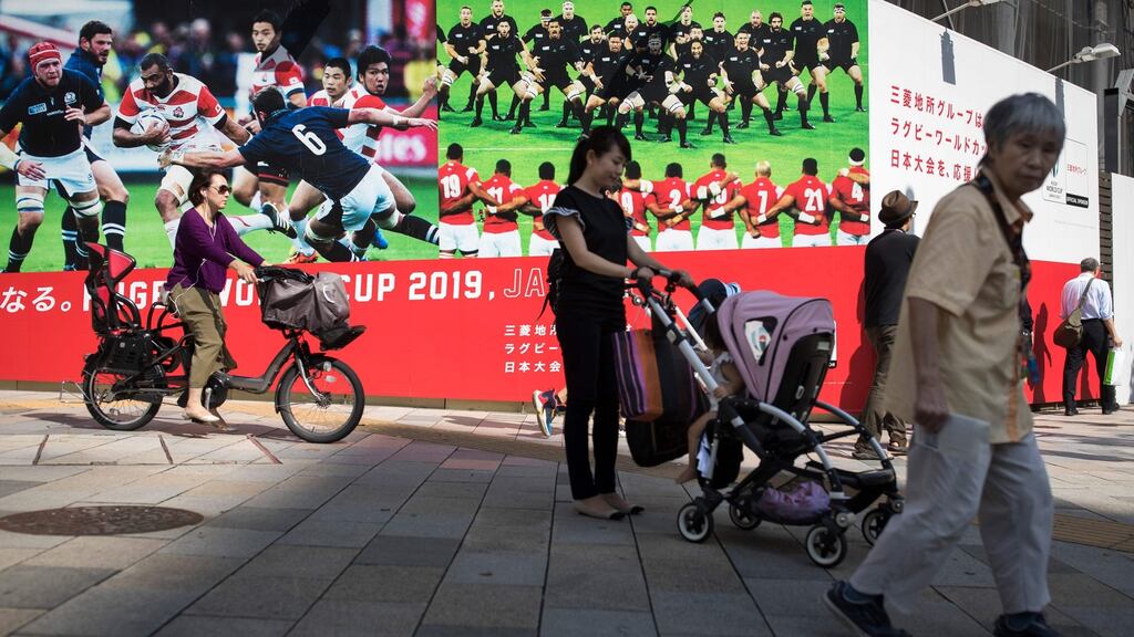 Commuters walking  past posters advertising the Rugby World Cup in the Tokyo district of Aoyama. Photograph: Odd Andersen/AFP/Getty Images