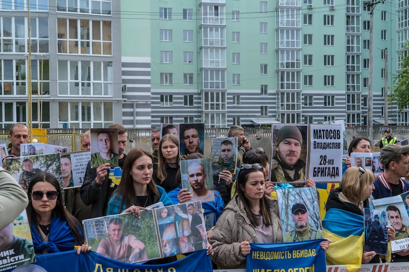 Family members hold images of their loved ones. Photograph: Brendan Hoffman/New York Times