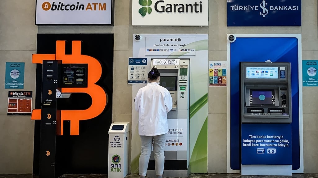 A woman uses a bank ATM next to a Bitcoin ATM machine at a shopping mall last week in Istanbul, Turkey. Photograph: Chris McGrath/Getty Images