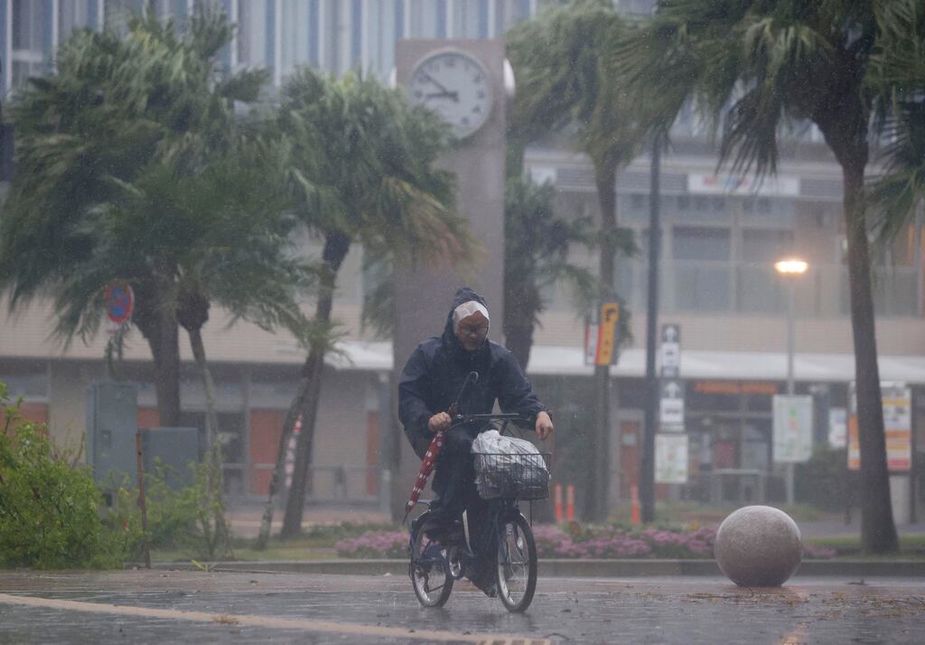 A man on a bicycle makes his way through the rain in during the typhoon in Miyazaki, southern Japan. Photograph: Kyodo News/AP.