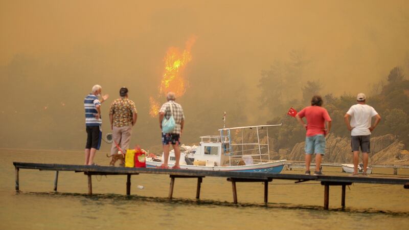Tourists wait to be evacuated from the smoke-engulfed Mazi area as wildfires rolled down the hill toward the seashore, in Bodrum, in Mugla, on Sunday. Photograph: Emre Tazegul/AP Photo