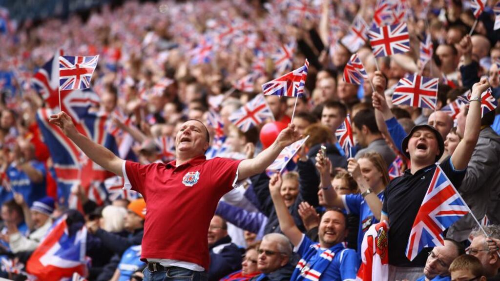 Rangers supporters wave Union Jack flags during a match against Celtic in Ibrox Stadium.Phhotograph: Jeff J Mitchell/Getty Images