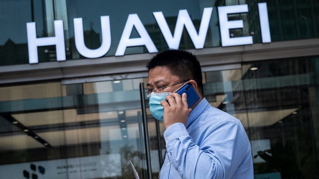 A man walks past a shop for Chinese telecoms giant Huawei in Beijing. The telecom giant says it achieved a record profit last year. File photograph: Nicolas Asfouri/AFP via Getty Images