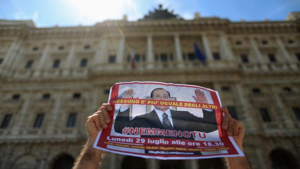 A man holds up a picture of former Italian prime minister Silvio Berlusconi as he protests in front of Italy’s supreme court building in Rome. The court today began considering Mr Berlusconi’s last appeal against a jail sentence and ban from public office for tax fraud. Photograph: Alessandro Bianchi/Reuters.