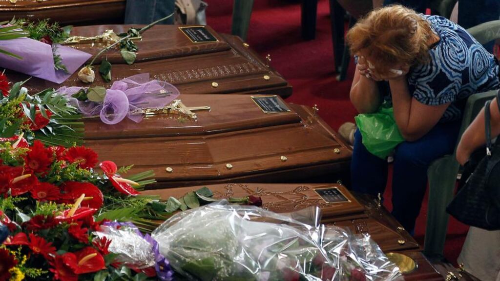 A woman mourns next to the coffins of victims of a coach crash at the Monteruscello Palasport near Pozzuoli today. Photograph: Reuters