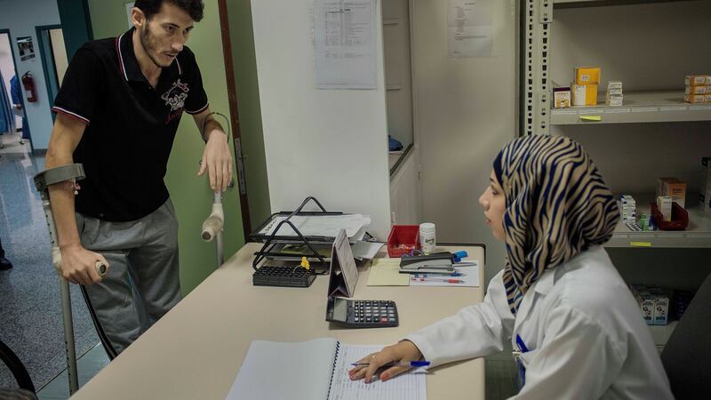 Mahmoud Hamadi, a Syrian refugee, talks with a pharmacist at the Médecins Sans Frontières (MSF) hospital in Amman, Jordan. Hamadi suffered a bullet wound. Photograph: Ted Nieters