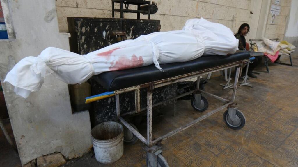 A shrouded dead body lies on a gurney in a street following a reported air strike by government forces on the Bustan al-Bashar district of the northern Syrian city of Aleppo yesterday. Photograph: Zein al-Rifai/AFP/Getty