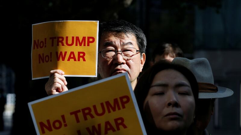 Protesters hold placards during a rally against US president Donald Trump’s visit to Japan, near the US Embassy in Tokyo on Friday. Photograph: Toru Hanai/Reuters