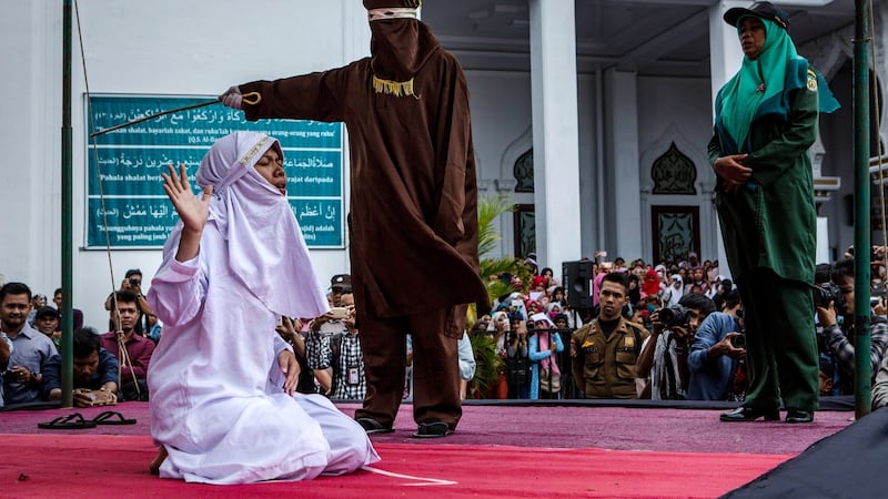A woman is caned in public for spending time with a man who is not her husband, which is against Sharia law, at Syuhada mosque in Banda Aceh, Indonesia. Photograph: Ulet Ifansasti/Getty Images
